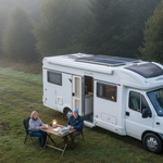 Couple with motorhome and solar panels off-grid