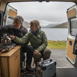 Couple using off-grid power system in campervan