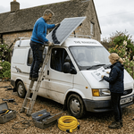 Couple installing solar panel on campervan roof