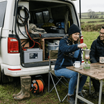 Couple at campervan showing battery storage setup