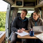 Couple reviewing campervan solar setup inside van