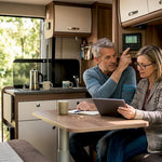 Couple checking battery panel in campervan interior