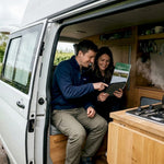 Couple managing campervan energy in rural UK setting