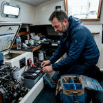 Man checking boat battery system in cabin