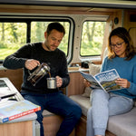 Couple relaxing in campervan interior