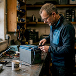 Man inspecting lithium leisure battery in home workshop