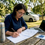 Woman planning campervan energy setup outdoors