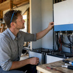 Technician inspecting hybrid inverter unit indoors