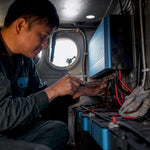 Electrician installing inverter inside boat