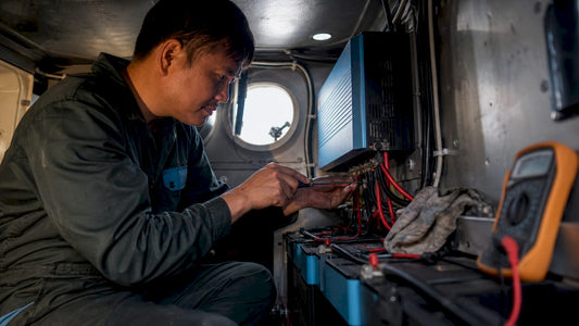 Electrician installing inverter inside boat